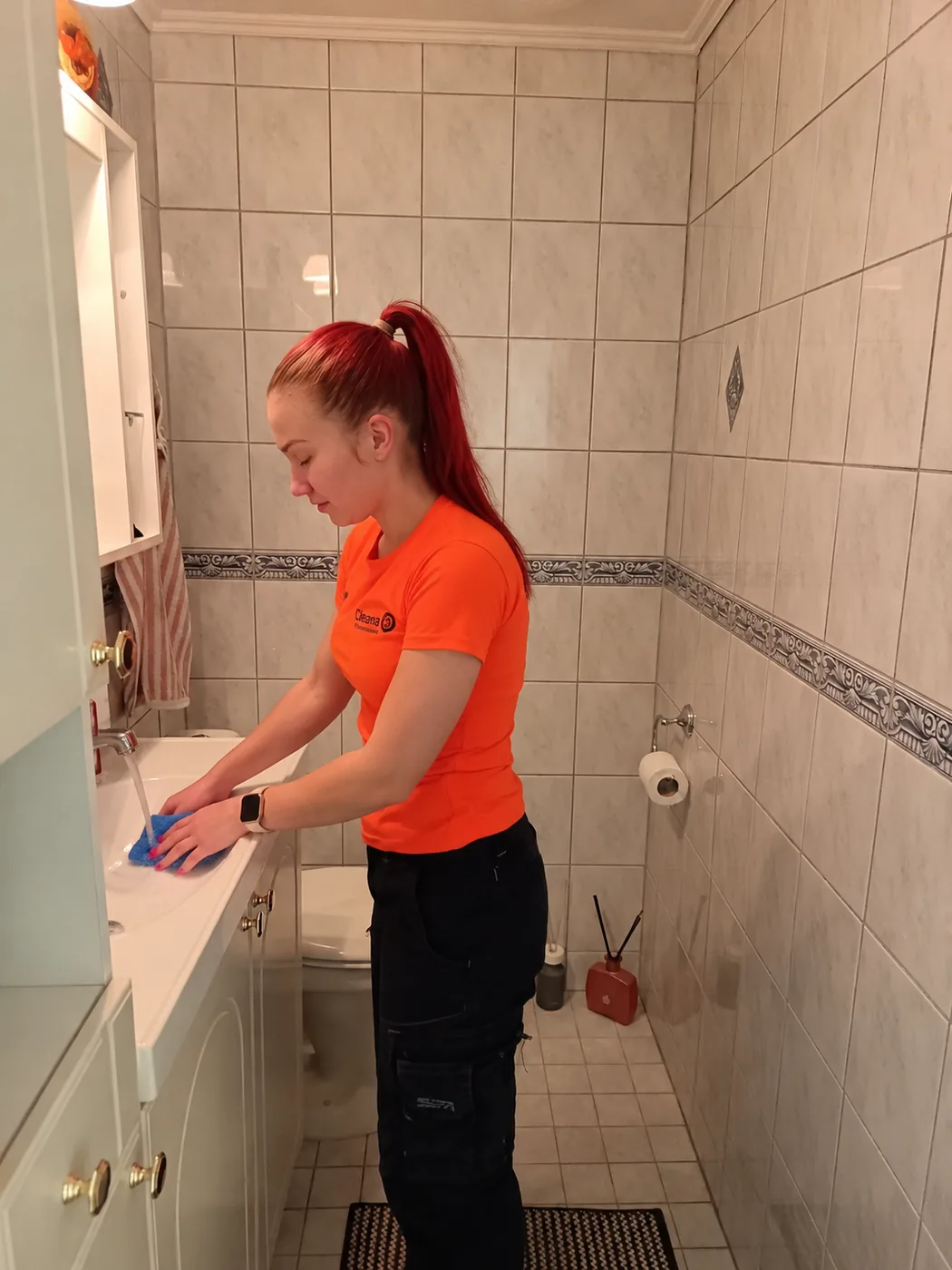 Cleanan ty&ouml;ntekij&auml; pesee kylpyhuoneen lavuaaria