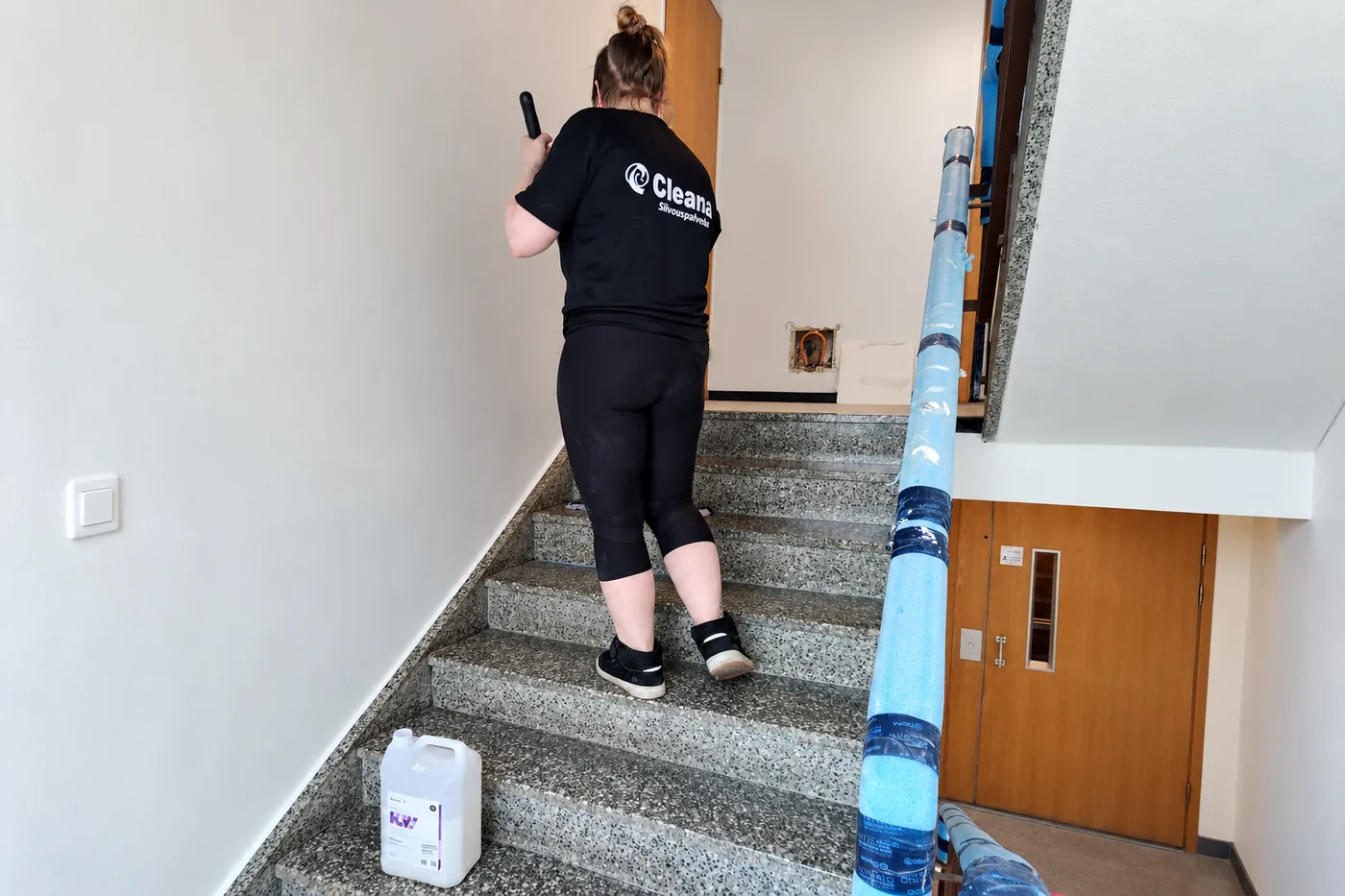 Cleanan ty&ouml;ntekij&auml; vahaa porrask&auml;yt&auml;v&auml;n portaita